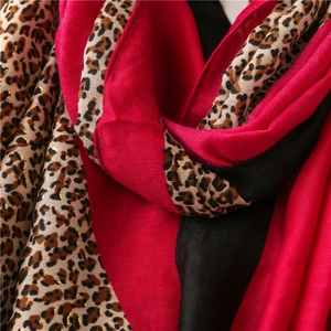 Detail of red and black scarf with gold foil leopard print and soft textured fabric