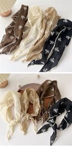 Detail of four cotton linen triangle scarves with floral embroidery and lace trim