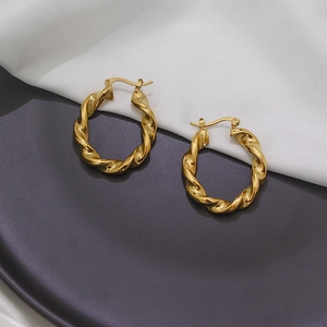 Détail de boucles d'oreilles créoles torsadées dorées 18 carats avec fermoir