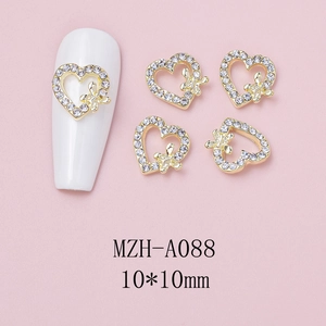 Macro detail of 10x10mm heart-shaped gold alloy nail charms with rhinestones and butterfly