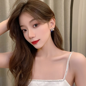 Close-up of elegant S925 silver bow stud earrings with sparkling crystals on model's ear