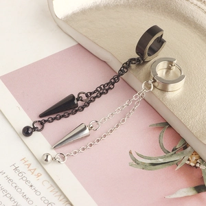 Detailed macro view of black and silver titanium steel hoop earrings with cone pendants