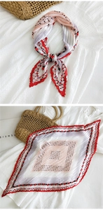 Dettaglio di un foulard quadrato plissettato con motivi geometrici rossi e rosa e bordi