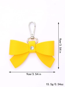 Detailed view of yellow leather bow keychain with crystal and silver clasp, size 9cm