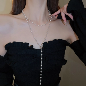 Élégant collier en Y à double couche de perles synthétiques sur un modèle en haut noir