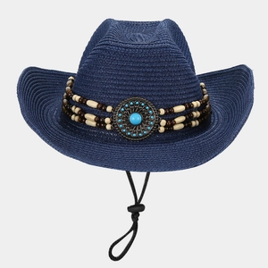 Detail of blue straw cowboy hat featuring beaded band and turquoise metal ornament