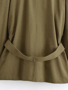 Detail of army green military jacket featuring back belt and twill fabric texture