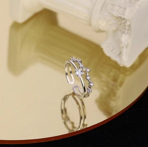 Macro detail of silver double-layer star ring with zircon inlay on a golden base