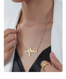 Detailed view of an 18K gold heartbeat necklace worn by a professional model
