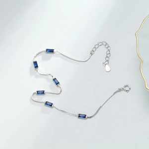 Detailed macro view of S925 sterling silver box chain with rectangular blue zircon stones