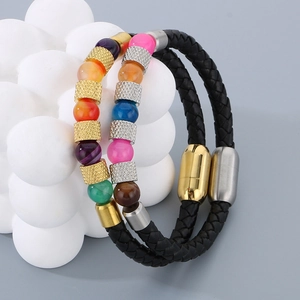 Dettaglio di bracciale in pelle intrecciata con perline colorate e chiusura magnetica in acciaio