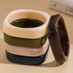 Retro geometric square resin bracelets in varied colors on a minimalist beige background