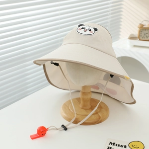 Dettaglio cappello sole beige per bambini con toppa panda e fischietto di sicurezza