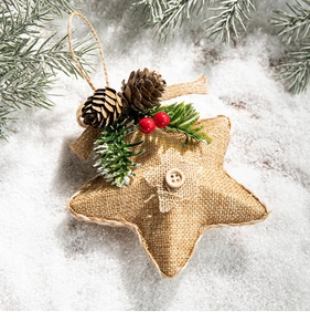 Detailed view of rustic burlap star ornament with pine cones, red berries and wood button