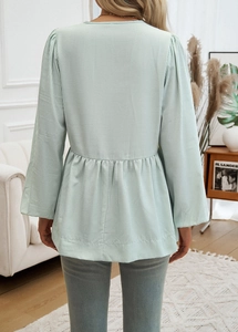 Detail of light green striped long sleeve top featuring a high waist and back tie design