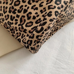 Macro shot of stitching details and leopard print texture on canvas tote bag