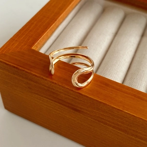 Dettaglio dell'anello a onde dorato a doppio strato su una scatola di legno pregiato