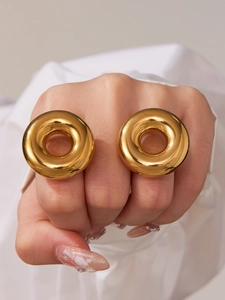 Close-up of chunky gold hollow dome rings on fingers with mirror-like polished finish