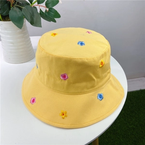 Close-up of colorful floral embroidery on a yellow cotton sun hat for women