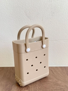 Detail of khaki EVA beach tote showing perforated design and white rivet fasteners