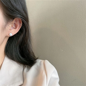Detailed view of irregular baroque pearl earring with small sparkling diamond accents