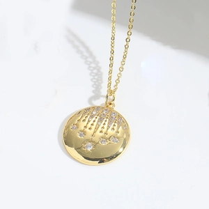 Detailed view of a gold pendant with embedded crystals and dangling star fringe elements