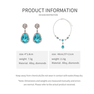 Detailed view of teardrop pendant necklace and earrings with light blue crystals