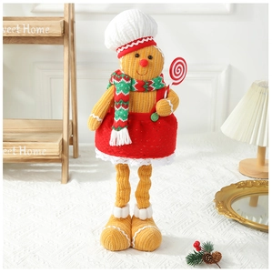 Close-up of a gingerbread man plush toy with a chef hat and red striped scarf detail