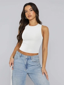 Close-up of white ribbed knit sleeveless crop top paired with high-waist jeans
