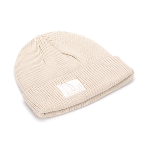 Dettaglio del berretto in maglia beige con trama a coste e toppa con L ricamata rosa