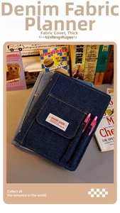 Detail view of denim fabric notebook cover featuring functional pockets and woven labels