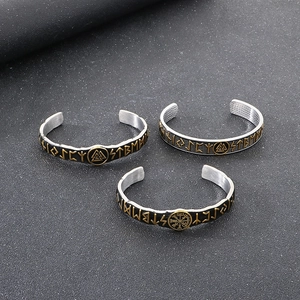 Macro detail of Viking rune bracelets with Valknut and Vegvisir icons in black and gold