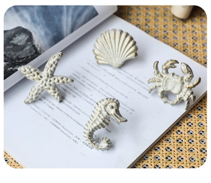 Detailed macro view of vintage Mediterranean nautical cabinet handles in starfish and shell shapes