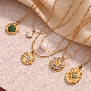 Detailed flat lay of 18K gold-plated necklaces with natural stone and shell pendants