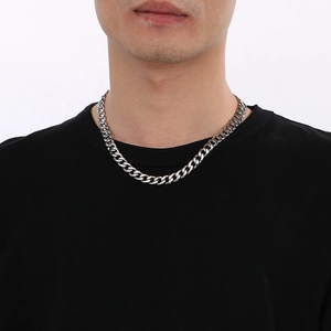 Gros plan d'un collier en maille Figaro en acier inoxydable argenté porté par un homme