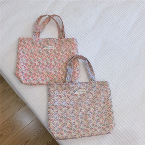 Détail de deux sacs fourre-tout en coton avec des motifs floraux vintage roses et bleus