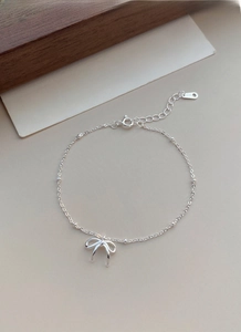 Detail of S925 sterling silver bow bracelet with metal beads and adjustable extension chain