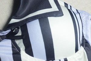 Vue détaillée du tissu satiné à rayures bleues et blanches avec nœud noir et coutures