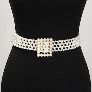 Detail of elegant multi-row pearl woven belt with square pearl buckle on a black mannequin