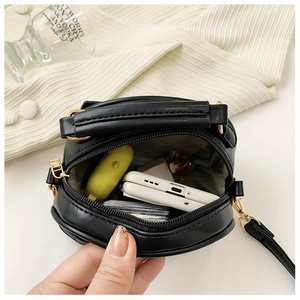 Top view of compact black PU leather mini crossbody bag showing internal storage capacity