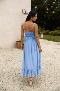 Détail de robe d'été bleu clair avec taille smockée, volants et fines bretelles