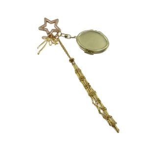 Golden locket and star carabiner charm with metallic fringe and bow design accessories