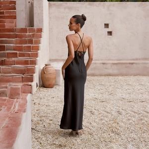 Detail of cross-back lace-up ties on a black satin backless maxi dress for women