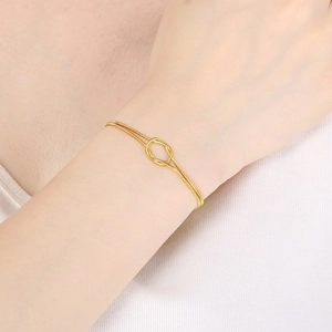 Minimalist 18K gold-plated knot snake bracelet worn on wrist for an elegant style
