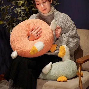 Plush white goose cushion and pink round ring pillow made of soft textured fabric