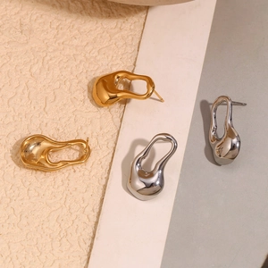 Vue détaillée de boucles d'oreilles irrégulières creuses en finitions or et argent