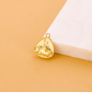 Gros plan sur un pendentif triangulaire doré avec un panda endormi et gravure ZZZ