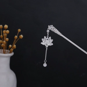 Detailed close-up of silver hollow lotus hair pin with tassel and turquoise bead