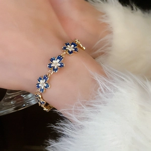 Macro shot of French vintage flower bracelet with gold metal and blue enamel petals