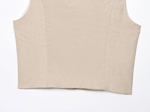 Detail of beige linen fabric texture and stitching on sleeveless vest top and shorts set